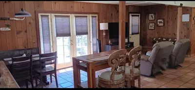 a dining room with a wooden table and chairs at 1948 Cottage with today's amenities in Bass Lake Annex