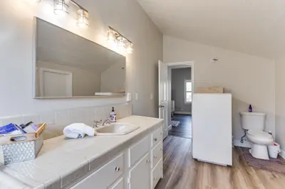 a bathroom with a sink and a toilet and a mirror at Beautiful Kernville Home with Game Room and Mtn Views! in Kernville