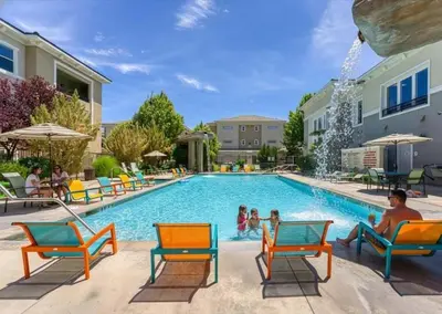 a swimming pool with chairs and people in a resort at Relaxing 2-BR Apt with Pool Hot Tub Gym and Basketball Court Access in Reno