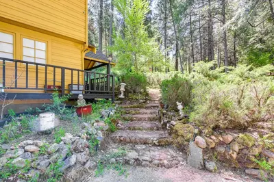 a stairway leading to a house with a yellow house at On-Site River Access Quiet Home in Wilseyville! in Wilseyville