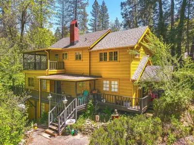 a large yellow house in the woods at On-Site River Access Quiet Home in Wilseyville! in Wilseyville