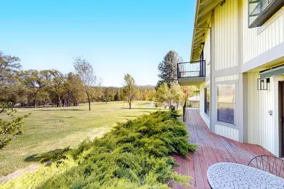 a porch of a house with a table and a field at Fair Days on the Fairway in Groveland