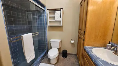a bathroom with a toilet and a sink at Knotty Pine Cabin with Artisan Stone Patio - Walk to Bass Lake in Bass Lake