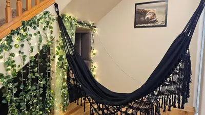 a hammock in a room with a plant at Knotty Pine Cabin with Artisan Stone Patio - Walk to Bass Lake in Bass Lake