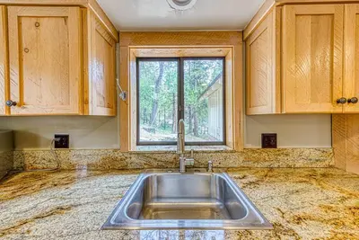 a kitchen with a sink and a window at Baxter Mountain Cottage in Shaver Lake