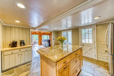 a kitchen with a large island with a vase of flowers at Baxter Mountain Cottage in Shaver Lake