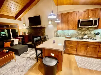 a kitchen with a counter and a living room at Newly Renovated Family Lake House, Private Beach! in Tahoma