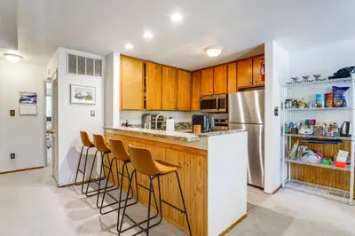 a kitchen with wooden cabinets and a white refrigerator at Steps to Lake Scenic Carnelian Bay Retreat in Carnelian Bay