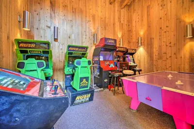 a room with two arcade games and a table at Steps to Lake Scenic Carnelian Bay Retreat in Carnelian Bay