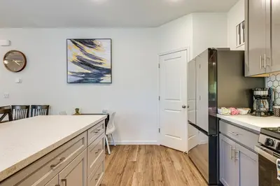a kitchen with white cabinets and a black refrigerator at Spacious Family Home in Stockton - Pets Welcome! in Stockton