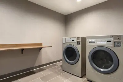 a laundry room with a washing machine and a shelf at Tru By Hilton Lodi in Lodi
