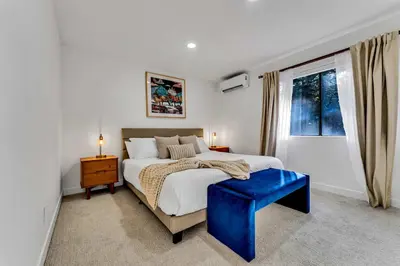 a bedroom with a large bed and a blue stool at Luxurious 7BR Walk 2 Beach and Bus Stop in Carnelian Bay