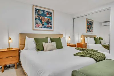 a bedroom with two large white beds with green pillows at Luxurious 7BR Walk 2 Beach and Bus Stop in Carnelian Bay