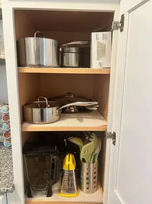 a cupboard with pots and pans and other kitchen items at Trinity Escape Entire home near Lodi Lake in Lodi