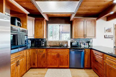 a kitchen with wooden cabinets and stainless steel appliances at The Venado House in Arnold