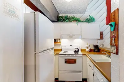 a kitchen with a white refrigerator and a stove at Bigwood 54 K in Mammoth Lakes