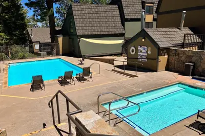 a swimming pool with chairs and a dog house at Bigwood 54 K in Mammoth Lakes