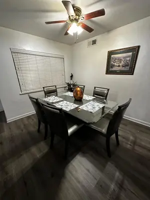 a dining room table with chairs and a ceiling fan at Casa Relajante in Visalia