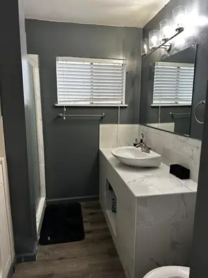 a bathroom with a sink and a toilet and a mirror at Casa Relajante in Visalia