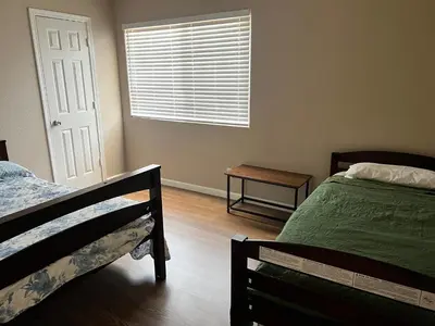 a bedroom with two beds and a window with a window blind at Serene 2bed 1bath condo with parking in Fresno