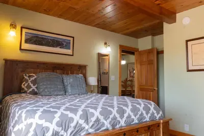 a bedroom with a bed in a room with wooden ceilings at Fern Grove - Hot Tub, Pet Friendly, Walk to Lake! in Tahoe City