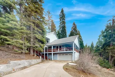 a house in the woods with a driveway at Under The Stars in Shaver Lake