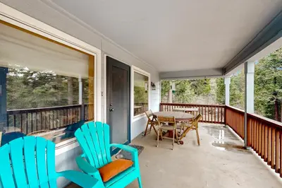 a screened in porch with chairs and a table at Under The Stars in Shaver Lake