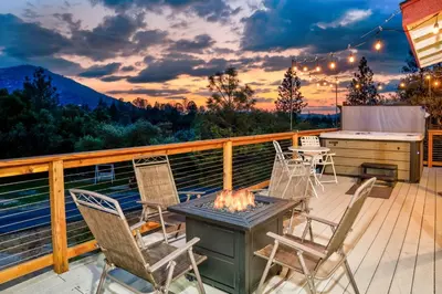 a deck with a table and chairs and a grill at Quail Haven- A-frame cabin with hot tub, views, and more in Oakhurst