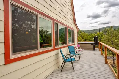 two chairs sitting on a porch with windows at Quail Haven- A-frame cabin with hot tub, views, and more in Oakhurst