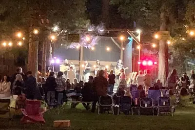 a group of people sitting in chairs at an event at night at Camp Cocktail - Cabin in the Heart of the Sierra, Arnold, CA in Arnold