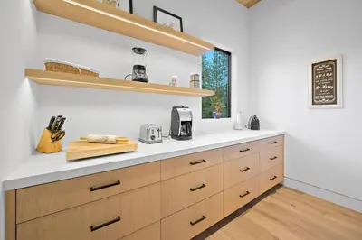 a kitchen with wooden cabinets and a window at Creekside Retreat - Near Palisades Tahoe in Olympic Valley