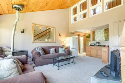a living room with a couch and a table at Auburn Cottage with Patios and Garden - 3 Mi to Town! in Auburn