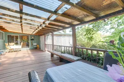 a porch with a wooden deck with a pergola at Auburn Cottage with Patios and Garden - 3 Mi to Town! in Auburn