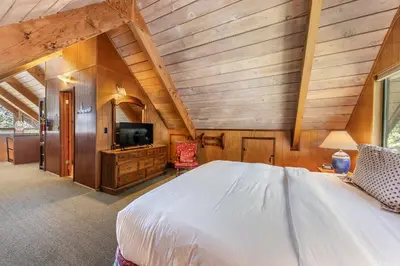 a bedroom with a large bed and a tv at 4BR Tahoe Retreat in Prime Location in Tahoe City