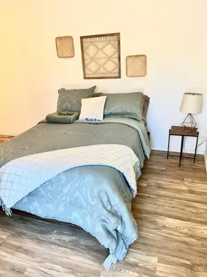a bedroom with a bed with a blue comforter at Remodeled Oasis in Visalia
