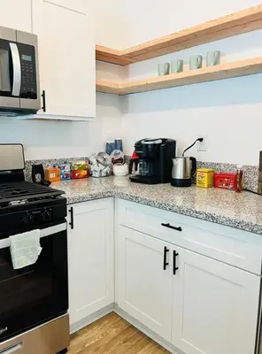 a kitchen with white cabinets and a black stove top oven at Remodeled Oasis in Visalia