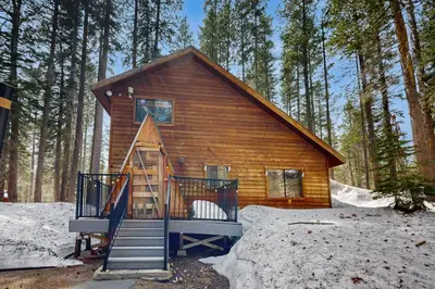 a log cabin with a staircase in the woods at Forest View in Soda Springs