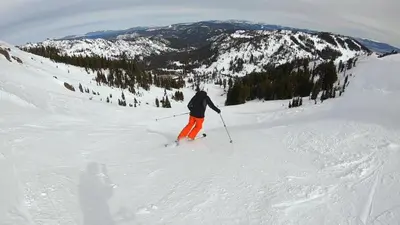 a man is skiing down a snow covered mountain at 2BR Mins to Alpine Base Area Palisades! in Alpine Meadows
