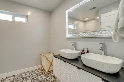 a bathroom with two sinks and a mirror at Walk to Midtown Charming Reno Retreat in Reno
