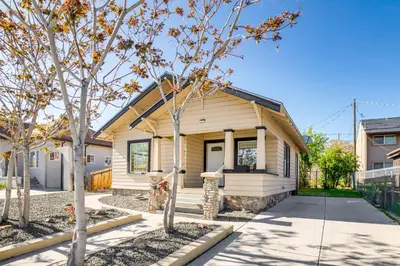 a small yellow house with trees in front of it at Walk to Midtown Charming Reno Retreat in Reno