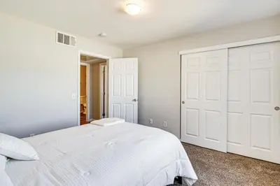 a bedroom with a white bed and a closet at 3 Mi to Downtown Reno Charming Condo with Patio in Reno