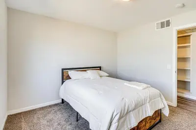 a bedroom with a bed with white walls at 3 Mi to Downtown Reno Charming Condo with Patio in Reno