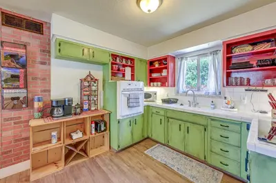 a kitchen with green cabinets and a brick wall at Family-Friendly Clovis Home with Gas Grill and Patio! in Clovis