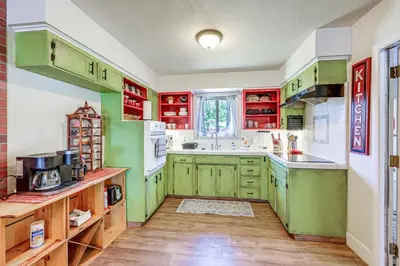 a kitchen with green cabinets and white appliances at Family-Friendly Clovis Home with Gas Grill and Patio! in Clovis