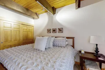 a bedroom with a bed and a table with a lamp at Tranquil Family Cabin in Incline Village