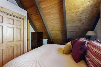 a bedroom with a bed and a wooden wall at Tranquil Family Cabin in Incline Village