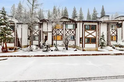 a house with snow on the ground in front of it at Tavern Inn #38 in Olympic Valley