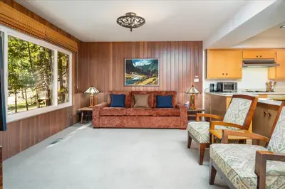 a living room with a couch and a kitchen at River's Edge w/ BBQ, Wifi, Firepit in North Wawona