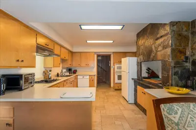 a large kitchen with wooden cabinets and white appliances at River's Edge w/ BBQ, Wifi, Firepit in North Wawona