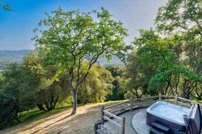 a bath tub on a dirt road with trees at Vista Haven with stunning views/hot tub/mini golf in Oakhurst